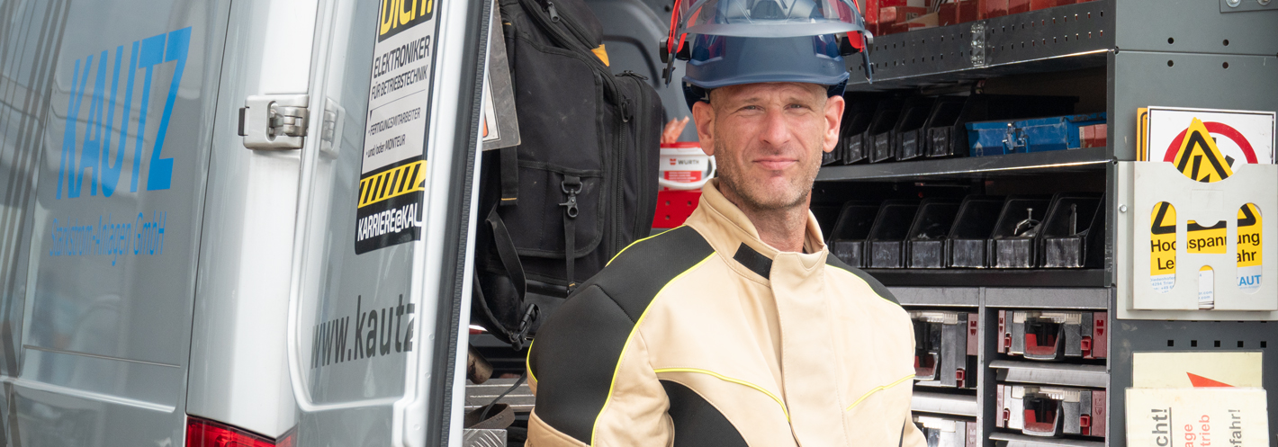 Foto eines Kautz Service-Technikers in Schutzkleidung von einem Servicewagen