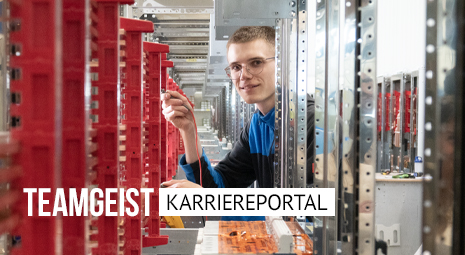 Foto eines Mitarbeiters in einer Flucht von Schaltanlagen in der Kautz Fertigung mit Bildbeschriftung: Teamgeist Karriereportal